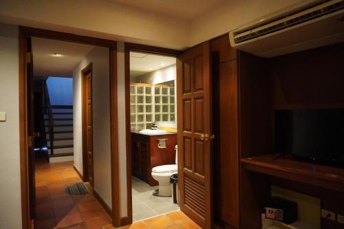 a bathroom with a toilet and a sink and a television at Bayview Villa by AaskResidy in Patong Beach