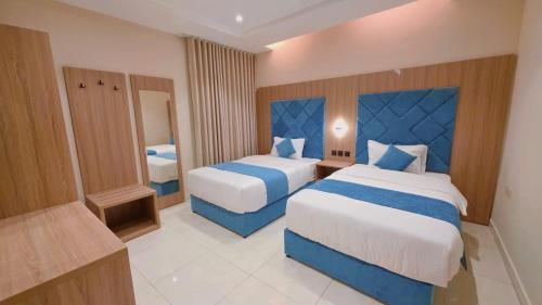 a hotel room with two beds and a bathroom at الديار الفاخرة - احد رفيدة in Ahad Rafidah