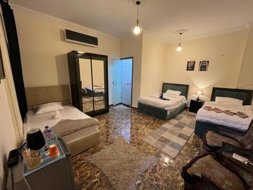 a hotel room with two beds and a mirror at Monument Pyramids View in Cairo