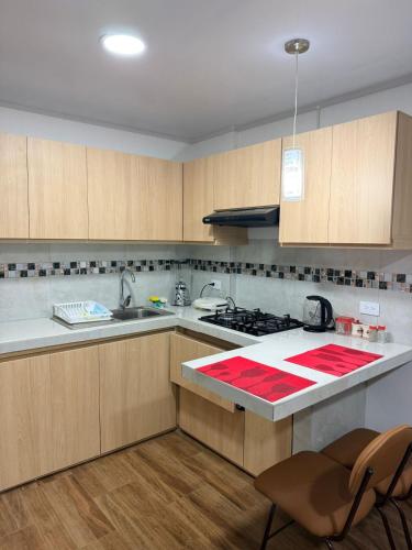 a kitchen with wooden cabinets and a counter top at Mini centrica suite privada con todo incluido in Loja