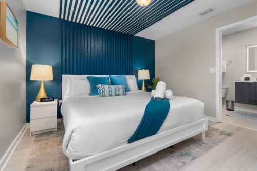 a bedroom with a large white bed with blue walls at Kid-Approved Stay Pool, Parks & Themed Rooms! in Kissimmee