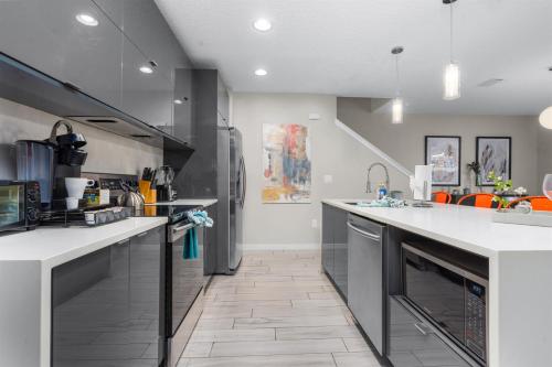 a large kitchen with white counter tops and appliances at Kid-Approved Stay Pool, Parks & Themed Rooms! in Kissimmee