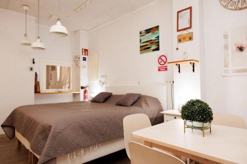 a bedroom with a bed and a table and chairs at Loft Valentia Olta Calpe in Calpe