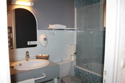 a bathroom with a sink and a shower and a tub at Don Quichotte in Vallet