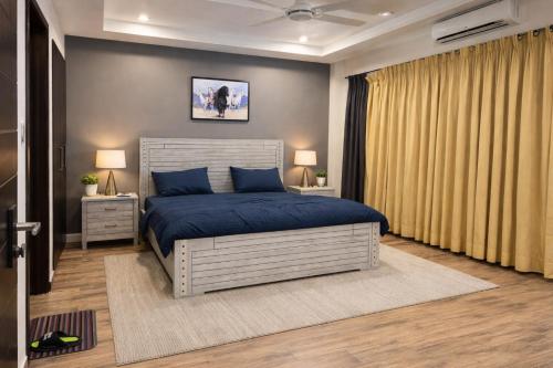 a bedroom with a blue bed and two night stands at Prime Stays Rezidor in Rawalpindi