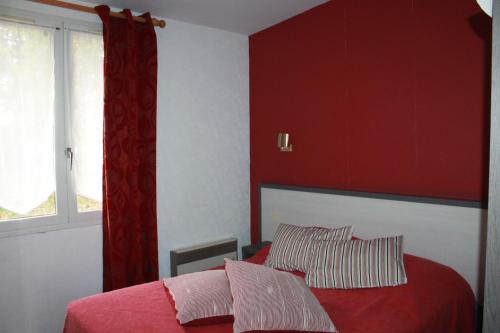 a red bedroom with a bed and a window at Don Quichotte in Vallet