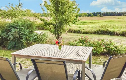 a wooden table with chairs and a vase of flowers on it at Nice Home In Röbel With Sauna in Röbel