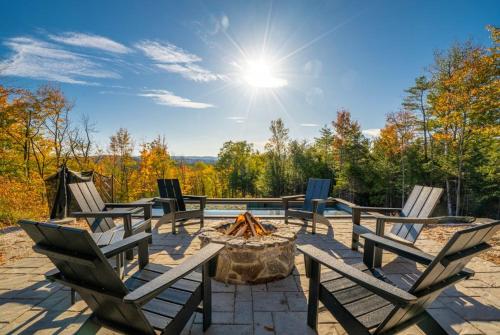 a group of chairs sitting around a fire pit at Epic Views, 9Mi SR, GameRmTheater, HTub, Sauna in Bethel