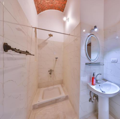 a white bathroom with a sink and a shower at Beit El Hanna Valley View in Luxor