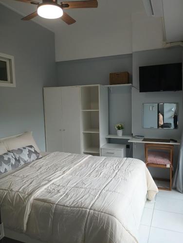 a bedroom with a bed and a flat screen tv at Tree Top Beach Condo in Ban Pak Khlong Phe