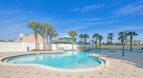 a swimming pool at a resort with palm trees at Beachfront Studio #909 at Majestic in Panama City Beach