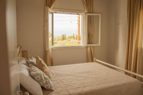 a bedroom with a bed and a window at Villa Aristidis Strates in Argyrádes
