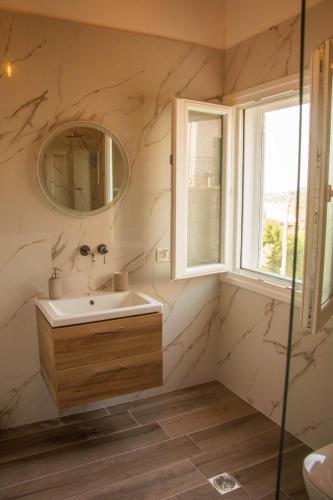 a bathroom with a sink and a mirror at Villa Aristidis Strates in Argyrádes