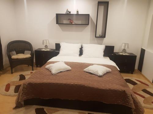 a bedroom with a large bed with two pillows on it at Apartament Teilor in Râşnov