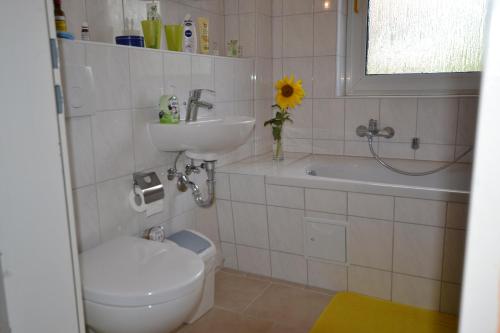 ein weißes Badezimmer mit einem Waschbecken, einem WC und einem Waschbecken in der Unterkunft TESLA 10km Pure Nature in Beerfelde