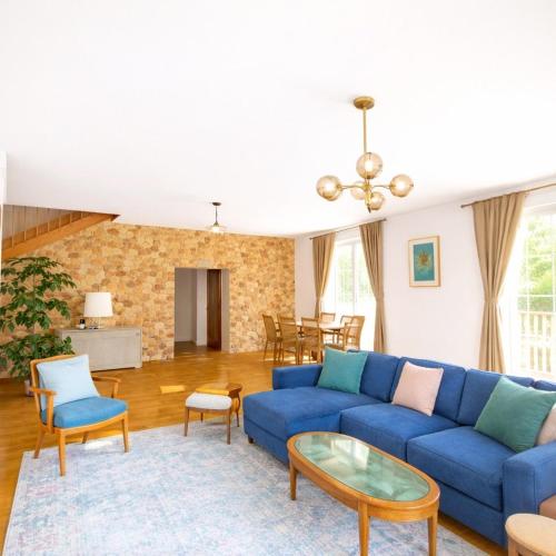 a living room with a blue couch and a table at La maison aux 5 nids in Saint-Cyr-sur-Loire