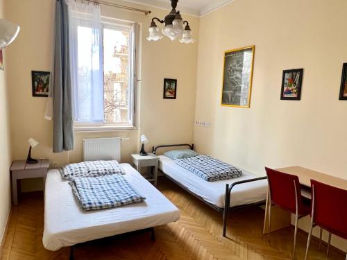 two beds in a room with a window at Bauhaus Astoria Hostel in Budapest