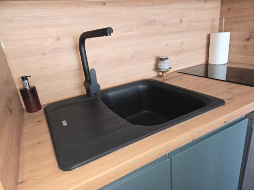 a kitchen counter with a black sink in a kitchen at Escale au Port du Crouesty in Arzon