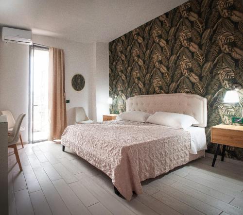 a bedroom with a bed and a wall mural at Hotel l'etoile de la ville in Montecatini Terme