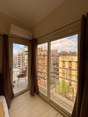 a room with two large windows with a view of a city at Calmaa Kairo in Cairo