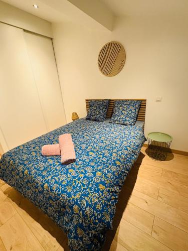 a bedroom with a bed with a blue comforter at L'Emile Zola l 2 Chambres l Hypercentre in Castres
