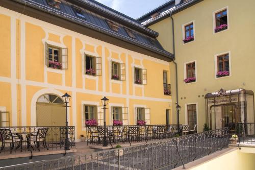 a building with a balcony and tables and chairs at Boutique Hotel ERB - Adults Only in Banská Štiavnica