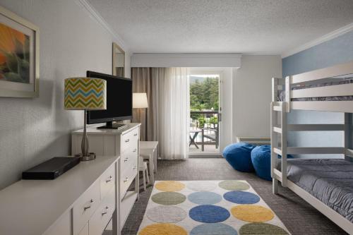 a bedroom with a bunk bed and a television at Holiday Inn Resort Lake George - Adirondack Area by IHG in Lake George