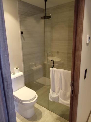a bathroom with a toilet and a glass shower at Park Life Tizate in Nuevo Nayarit