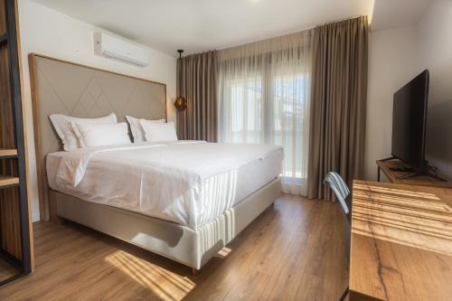 a bedroom with a large bed and a flat screen tv at The Hill Aparthotel in Mostar