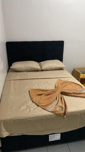 a bed with a brown blanket on top of it at Mega Hotel in Cascavel