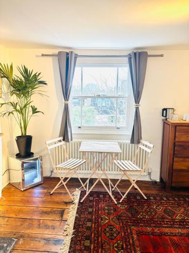 a living room with a table and chairs and a window at Central Victorian House in London