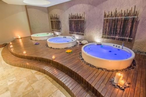 two large tubs in a bathroom with candles at GHL Hotel Monteria in Montería