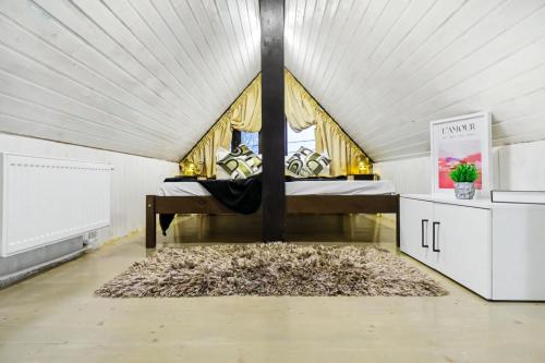 a bedroom with a bed in a white room at The HIDE - Loftette in Ploieşti