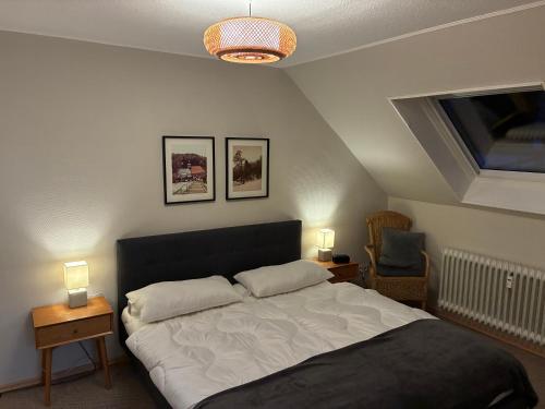 a bedroom with a bed with two lamps and a window at Harz-Urlaub-Altenau - Hunde willkommen in Altenau