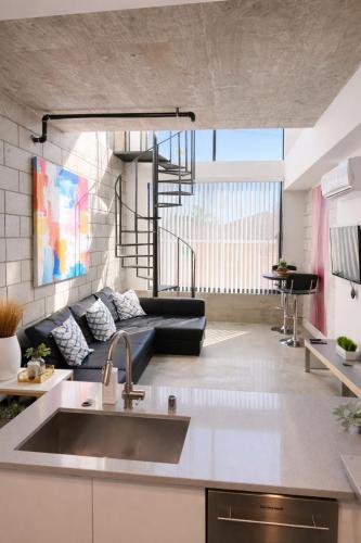 a kitchen and living room with a couch and a sink at CasaViva Loft - Modern 2BR with Garage Parking, In-Unit Washer Dryer & ADA Access - Walk to Hillcrest, 5 Min to Gaslamp & North Park in San Diego
