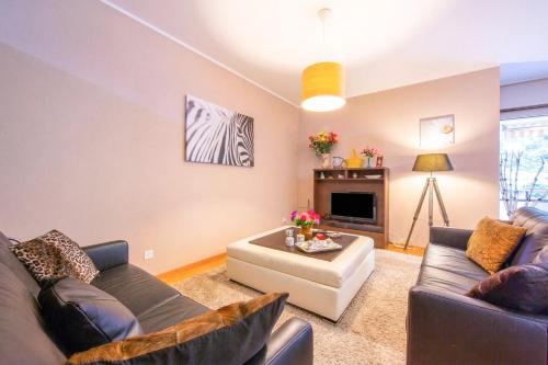 a living room with two couches and a table at Maraini Elegante Apartment with Jacuzzi & Balcony - Happy Rentals in Lugano