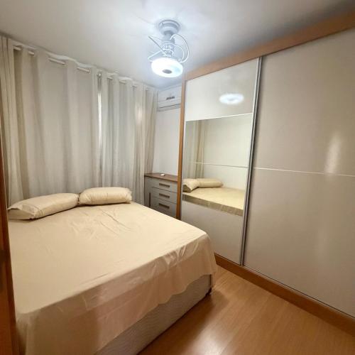 a bedroom with a bed and a large mirror at Apartamento completo e confortável em Duque de Caxias in Duque de Caxias