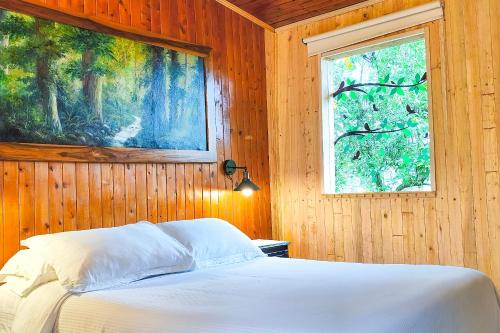 a bedroom with a bed with a painting on the wall at Chalé de montaña con Jacuzzi in Guarne