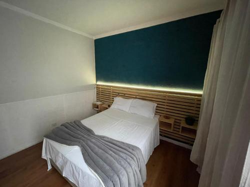 a small bedroom with a bed and a green wall at Loft em Butantã, próximo a USP in São Paulo
