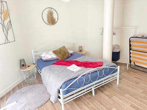 una camera da letto con un letto con una coperta rossa sopra di Escale 12 a Le Mans