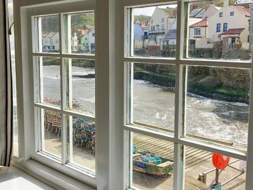 a window with a view of the water through it at The Anchorage in Staithes
