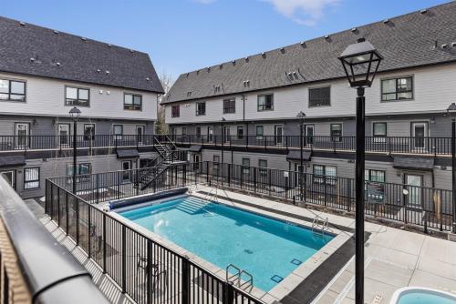 a swimming pool in front of a building at Cloudline Vista 3 BdrmTownhouse w Private Garage Views Pool Walk Downtown in Canmore
