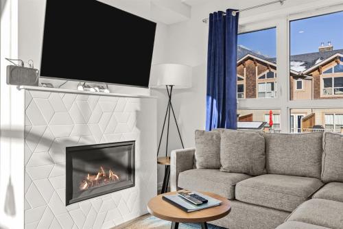 a living room with a couch and a fireplace at Cloudline Vista 3 BdrmTownhouse w Private Garage Views Pool Walk Downtown in Canmore