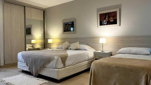 a hotel room with two beds and two lamps at LS Hotel in Salta