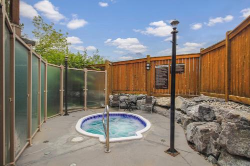 a hot tub in a patio with a fence at Spacious, Pet Friendly, Townhouse Hot Tub Perfect for Families! in Canmore