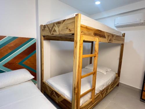 a bunk bed in a room with a ladder at Hostal Nomadas in Santa Marta