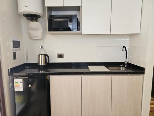 a kitchen with a sink and a microwave at Apartamentos TerraLoft in San Antonio