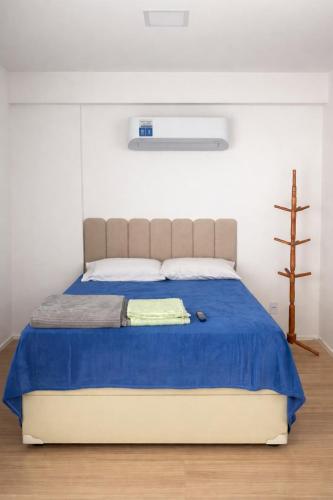 a bedroom with a large bed with a blue blanket at Sou mais Icarai in Niterói