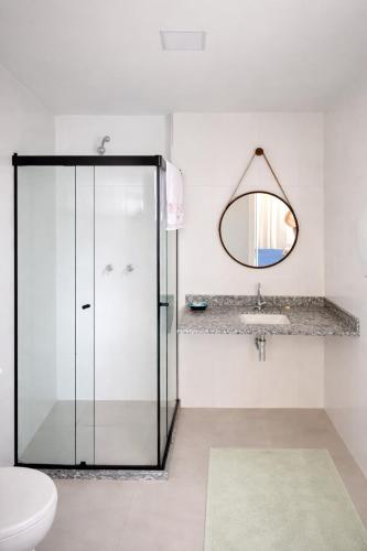 a bathroom with a glass shower and a sink at Sou mais Icarai in Niterói