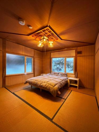 a bedroom with a bed in a room with windows at 呼人2 Arun別邸 in Abashiri